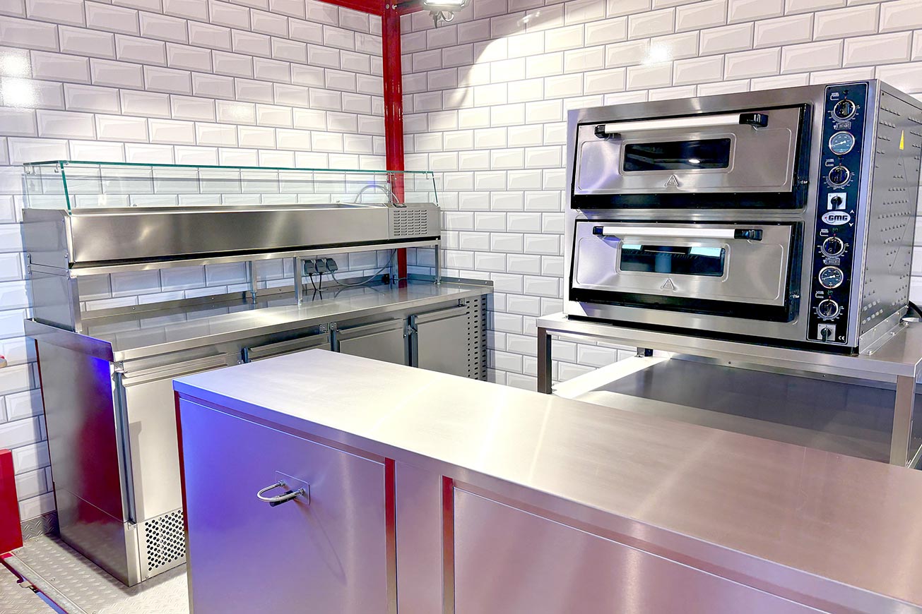 Rimorchio per pizza davanti a ROKA. Carrello ribaltabile per la vendita di pizza immediatamente disponibile.