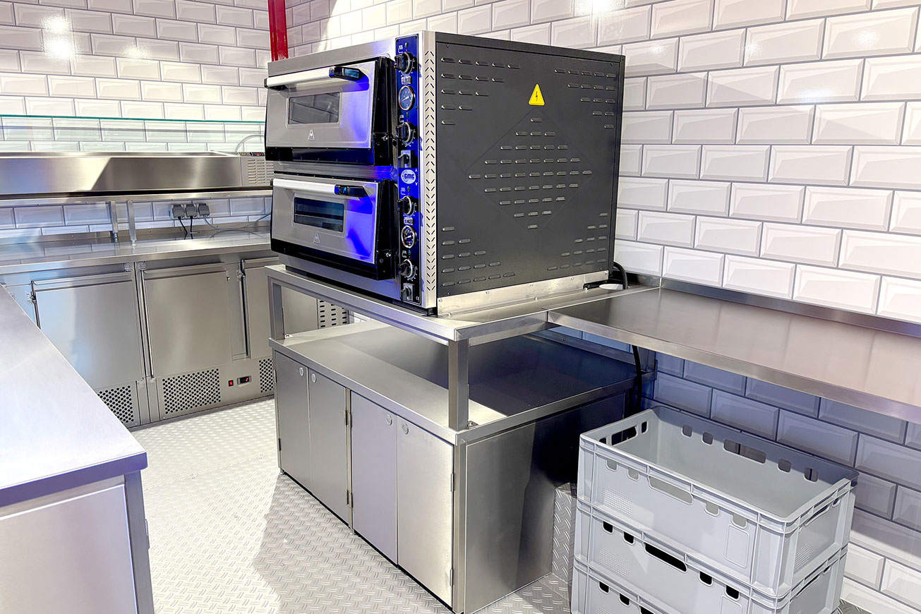 Rimorchio per pizza davanti a ROKA. Carrello ribaltabile per la vendita di pizza immediatamente disponibile.